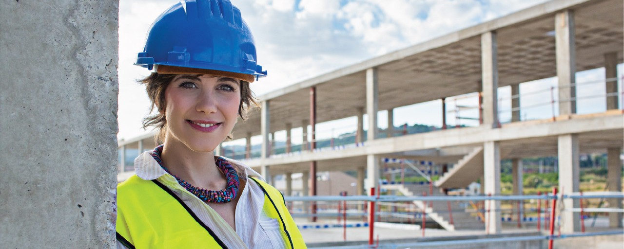 Female construction worker in front of building site.